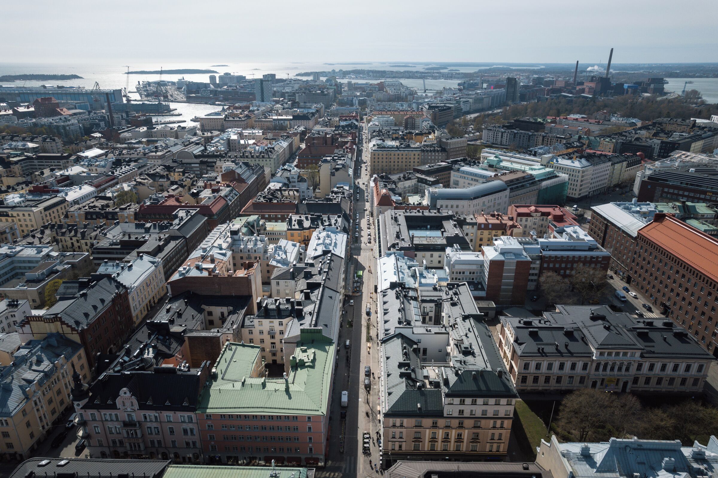 An aerial view of a cityscape with a prominent central avenue lined with historic buildings and modern structures.