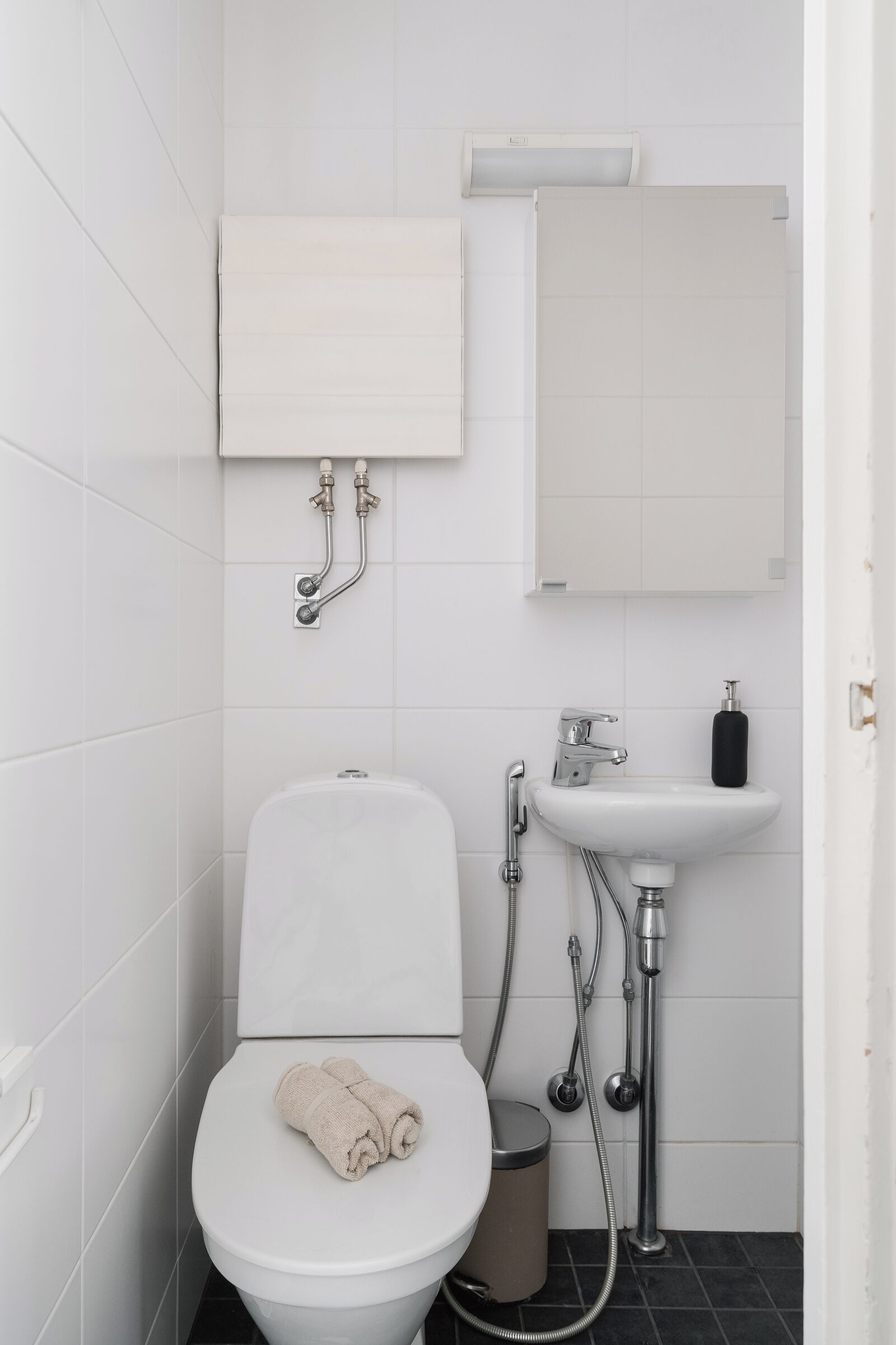 A modern bathroom with a toilet, sink, and shower.