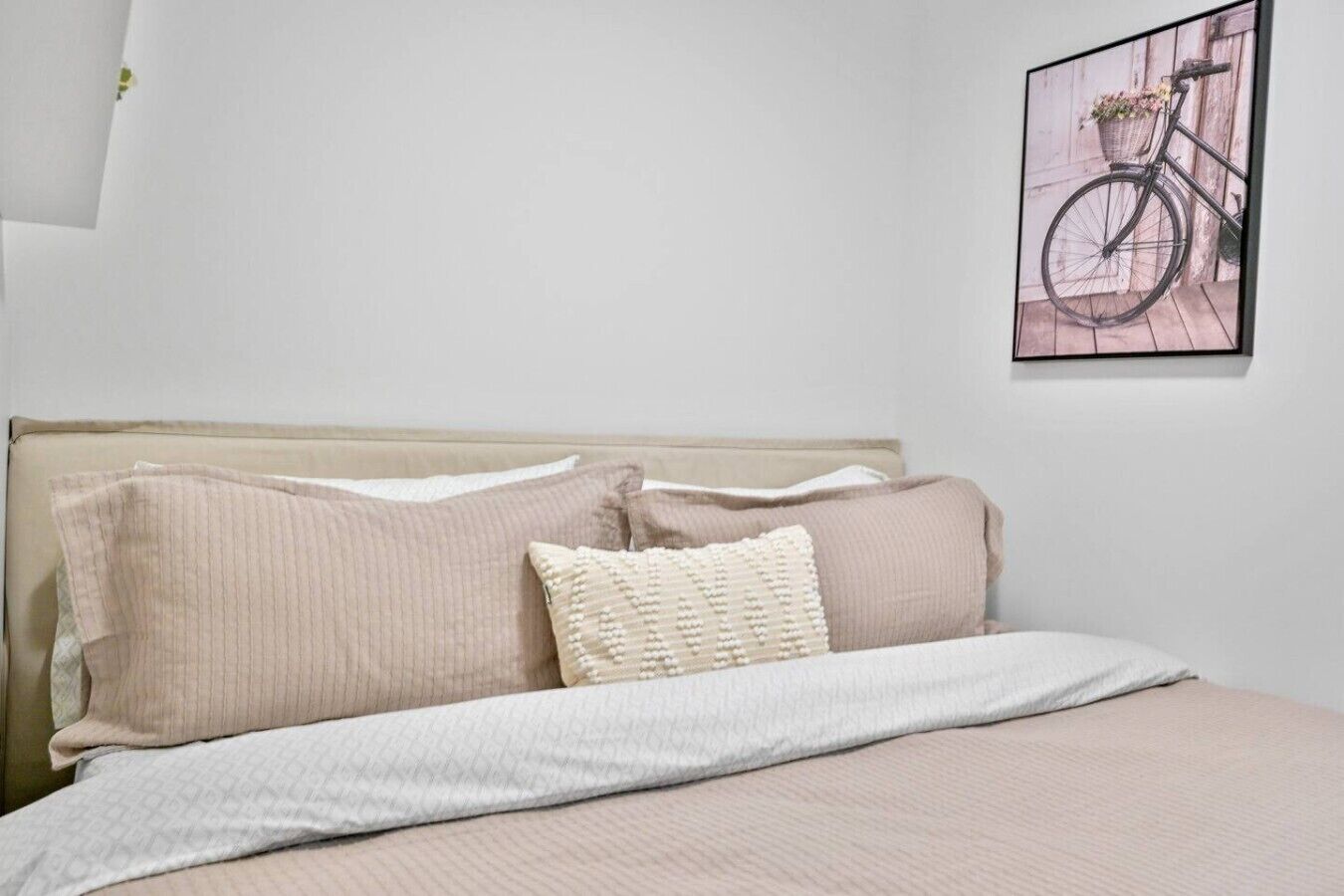 A bed with a headboard, two pillows, and a blanket.