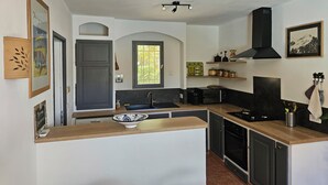 Una cocina compacta con una isla central, horno integrado y microondas.