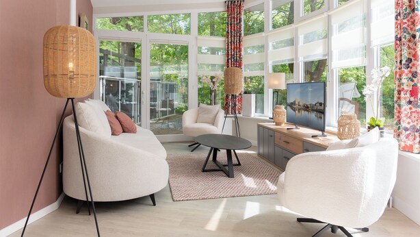 Een moderne woonkamer met een bank, een ronde tafel en een televisie.