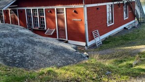 A red wooden building with a balcony, a garage, and a sign that reads "Ingebekkingen". - Siaröfortet (Ljustero)