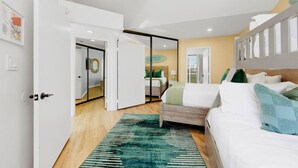 Un dormitorio moderno con una cama, una alfombra verde y una puerta corrediza que da a otra habitación.