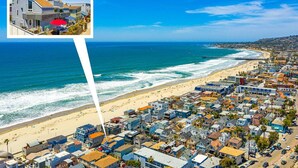 Un pueblo costero con playa, casas y un muelle.