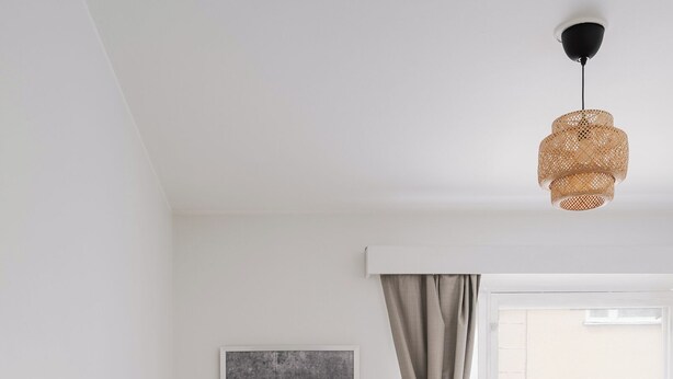 Ein modernes Schlafzimmer mit einem Bett, einem runden Couchtisch, einer Couch und einem Fenster mit Vorhängen.