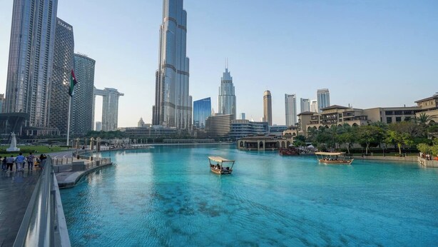 A waterfront view with modern skyscrapers, including a prominent tower with the name 'Emaar'. - Vogue | Downtown with Direct Access to Dubai Mall (Dubai)