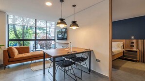 A modern room with a dining table, chairs, a sofa, and a bed. - w* | Welcoming 2BR in Laureles w/ City View (Medellín)