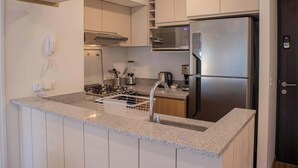 A modern kitchen with a built-in gas stove, stainless steel refrigerator, and a microwave. - w* | Amazing 2BR w/ Balcony in San Isidro (San Isidro)
