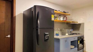 A compact kitchen with a black refrigerator, a microwave, a stove, and a sink. - w*| Breathtaking 2BR w/ AC in Bocagrande (Cartagena de Indias)