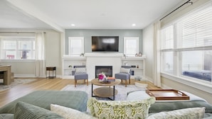 A living room with a fireplace, a flat-screen TV, and a sofa set.