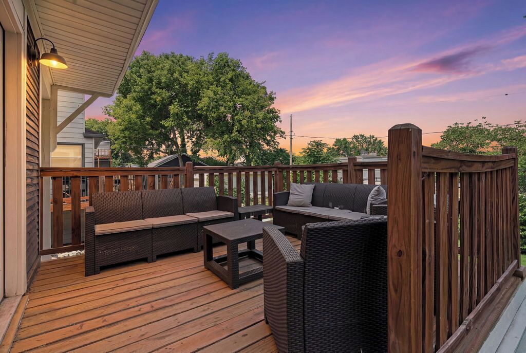 Eine Terrasse im Freien mit Korbmöbeln, darunter Sofas und ein Couchtisch.