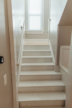A staircase leading to a landing with a window above.