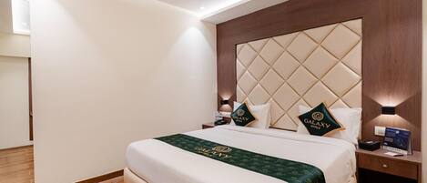 A hotel room with a large bed, a ceiling fan, and a nightstand with a lamp.