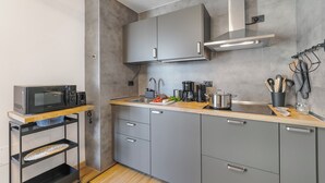 A modern kitchen with grey cabinets, a microwave, a coffee maker, and a sink. - Residenza I 3 Mori B - Balcony & Mountain Views (Arco)