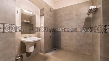 A bathroom with a sink, mirror, shower, and decorative tiles.