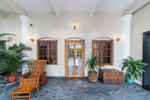 A lobby with a wooden bench, potted plants, and a sign reading 'Sarada Mandiram Heritage Abode'. - Sarada Mandiram A Heritage Hotel (Kanayannur)