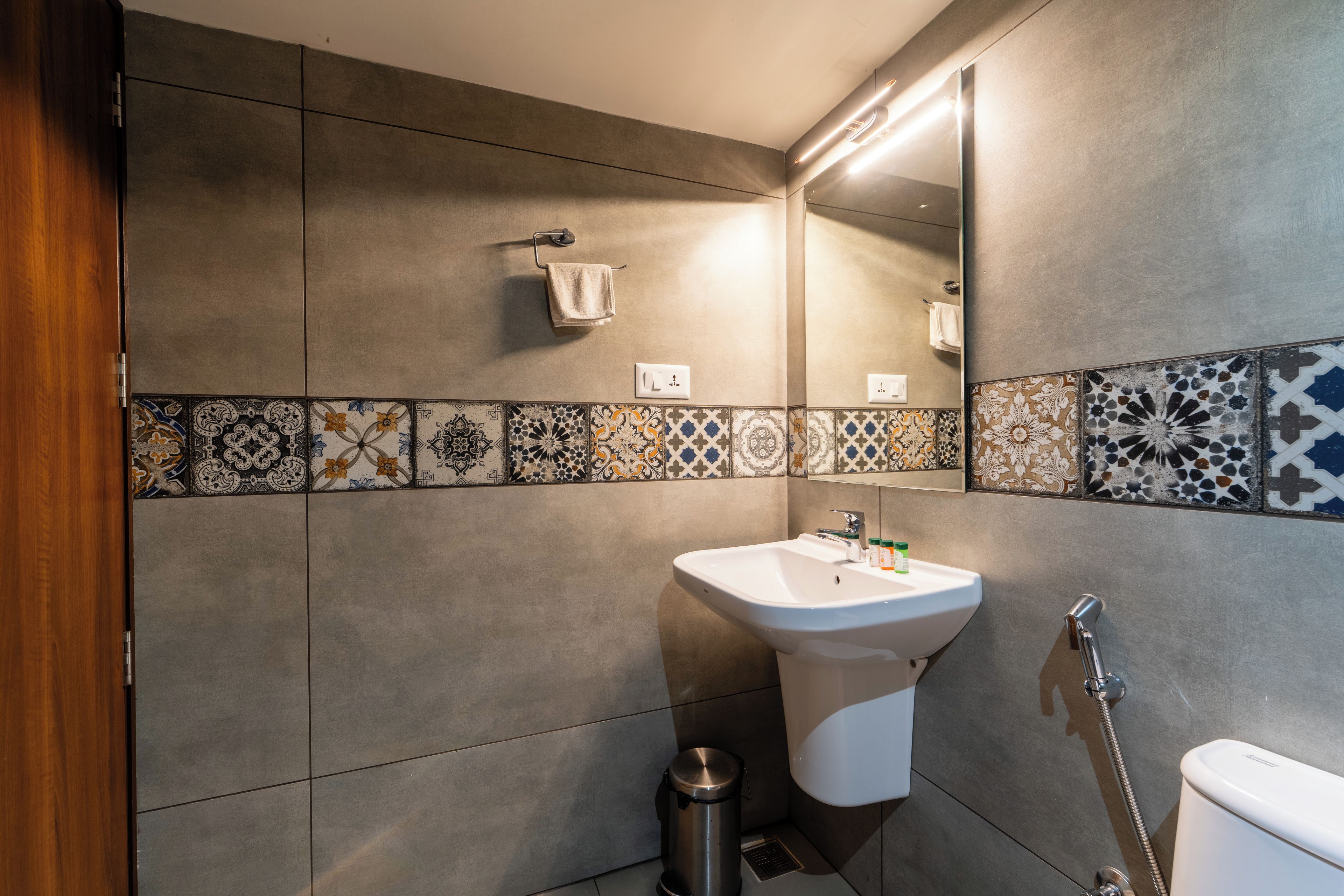 A modern bathroom with a white sink, a mirror, and a shower.