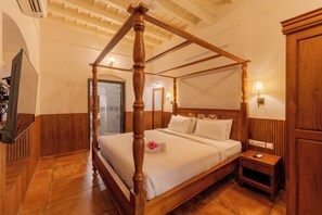 A four-poster bed with a wooden frame and a headboard with vertical panels. - Sarada Mandiram A Heritage Hotel (Kanayannur)