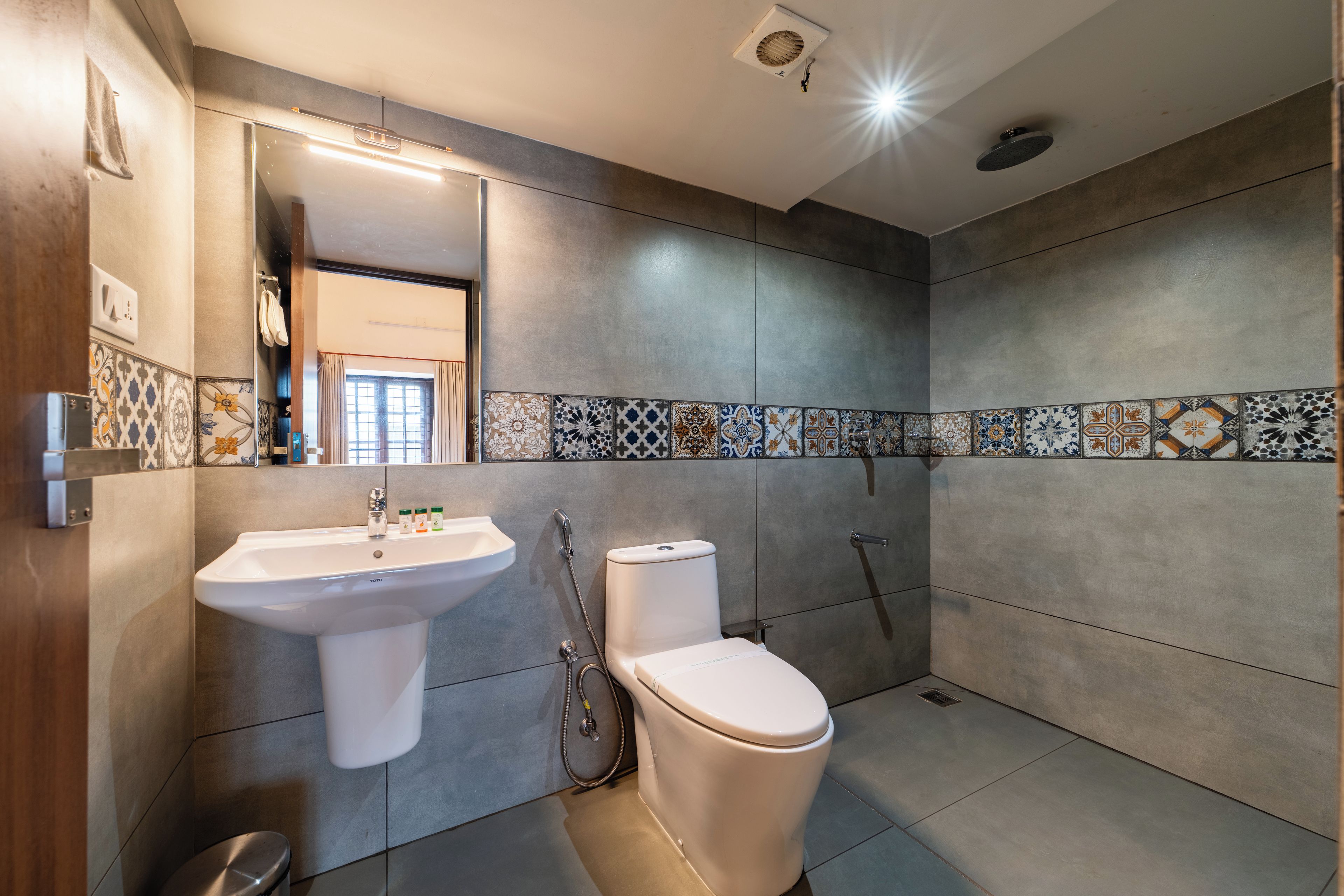 Un bagno moderno con lavandino, WC e doccia bianchi.