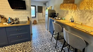 Eine moderne Küche mit einem schwarz-weißen Fußboden, einer Holztischplatte und einer Bar mit Hocker.