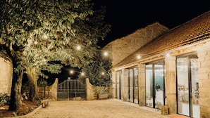 A stone building with a tiled roof, a gated entrance, and a paved courtyard. - Solar de Vilar Seco (Nelas)