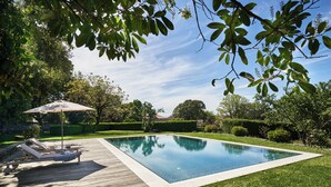 A rectangular swimming pool with a wooden deck and lounge chairs. - Solar de Vilar Seco (Nelas)
