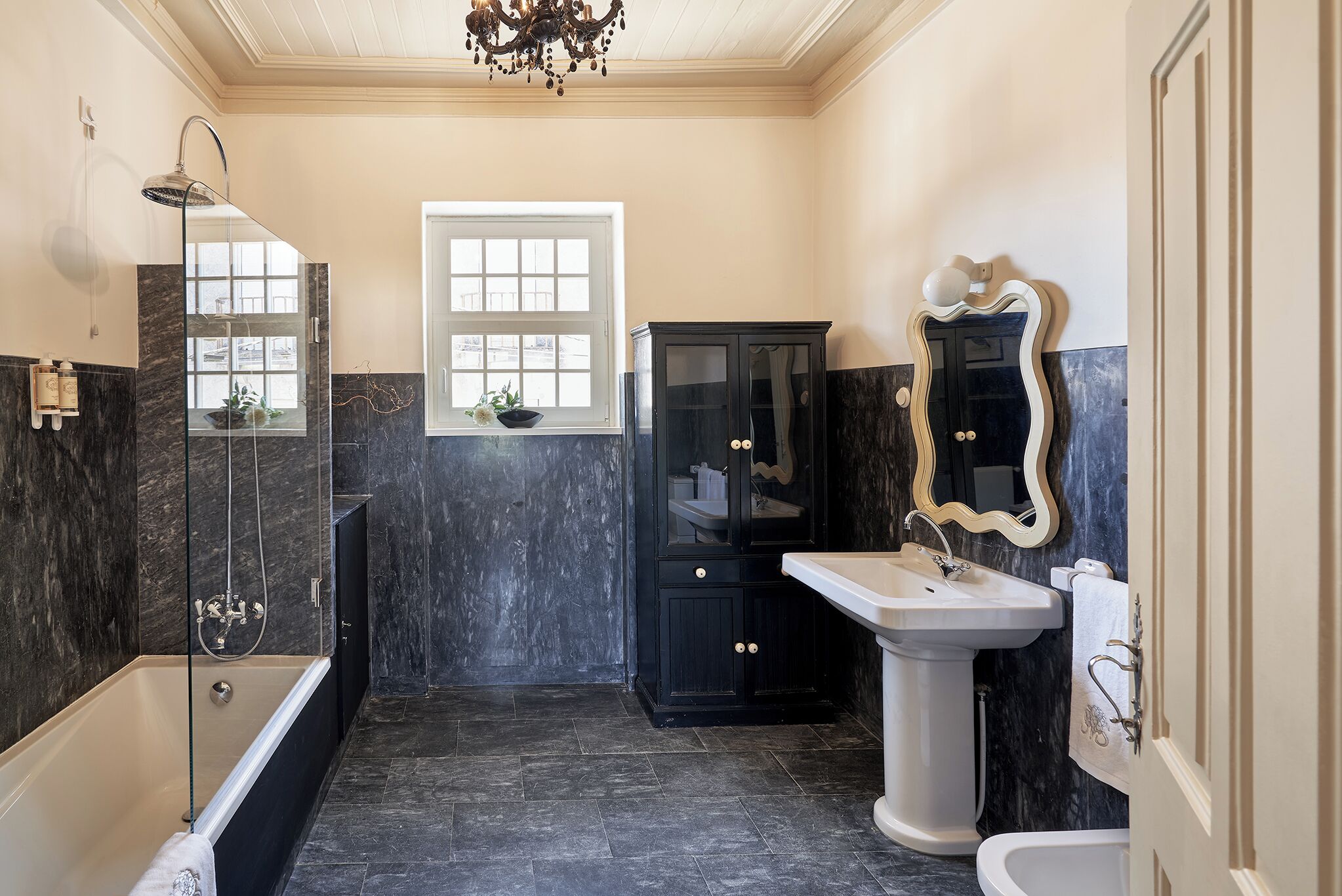 A bathroom with a bathtub, a sink, a vanity, and a shower.