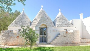 A white building with three conical roofs and a central door. - My Rental Homes - Trulli Heaven with private pool and large garden (San Michele Salentino)