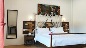 Una camera da letto con un letto, un comodino, uno specchio e un'opera d'arte appesa al muro.