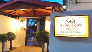 A Bungalows Resort entrance with a sign, potted plants, and a covered walkway. - vivi bungalows resort5 (Rawai)