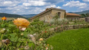 A stone building with a rustic appearance, surrounded by lush greenery and a clear sky. - Villa del fattore with pool - My Rental Homes (Greve In Chianti)