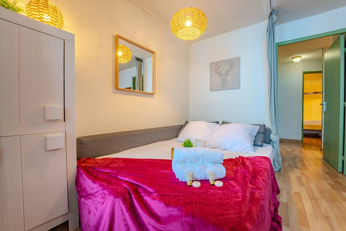 A neatly arranged bedroom with a bed, bedside table, and a wardrobe.