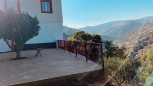 A two-story building with a balcony, a tree, and a mountainous landscape in the background. - Terraços do Távora - 2 Bedroom Apartment (Barcos)