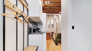 Eine moderne Küche mit einem Holztisch und Stühlen, einer Kaffeemaschine und einem Essbereich mit einem grünen Stuhl.