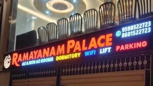 Ein verschlossener Hoteleingang mit einem Schild für Ramayananam Palace, das Gemeinschaftsschlafräume, WLAN und Parkplätze anbietet.