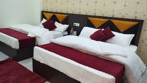 Ein Hotelzimmer mit zwei Betten, jedes mit einer roten Tagesdecke und weißen Bettwäsche.