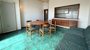 A compact living space with a dining area, kitchenette, and a sofa. - 2 Sea View Penthouse with Large Balcony (Bellaria-Igea Marina)