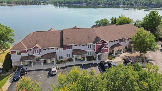 Un hôtel à plusieurs étages, doté d’un parking et offrant une vue sur un lac.