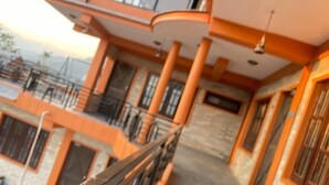 A multi-story building with balconies, large windows, and a staircase.