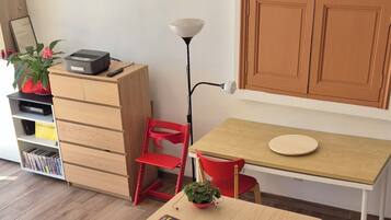 Una cucina moderna con un tavolo in legno, sedie rosse e un armadietto con un quadro sopra.