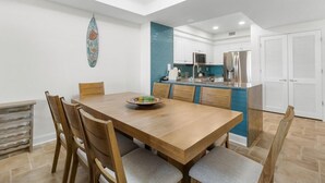Eine moderne Küche mit weißen Schränken, einer blauen Spritzschutzwand und Edelstahlgeräten.