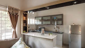 A modern kitchen with a marble island, stainless steel appliances, and a built-in oven. - The Galleria Home by Red Olive Yelahanka (Bengaluru)
