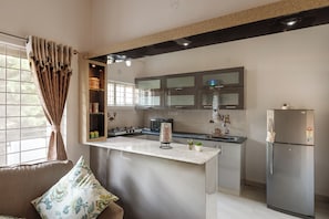 A modern kitchen with a marble island, stainless steel appliances, and a built-in oven.