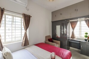 A hotel room with a bed, a desk, a chair, and a window with curtains. - The Galleria Home by Red Olive Yelahanka (Bengaluru)