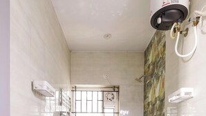 A bathroom with a toilet, shower, and a water heater. - The Nebula by Red Olive (Bengaluru)
