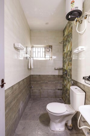 A bathroom with a toilet, shower, and a water heater. - The Nebula by Red Olive (Bengaluru)