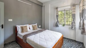 A bedroom with a bed, grey walls, a window with curtains, and a wooden floor. - The Nebula by Red Olive (Bengaluru)