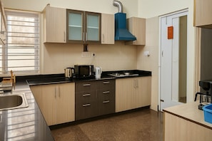 Una cocina moderna con armarios de madera, encimera negra y pileta de acero inoxidable.