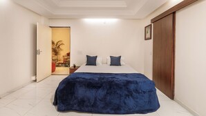 Ein Schlafzimmer mit einem Bett, einem Holzschrank und einer Tür zu einem anderen Raum.