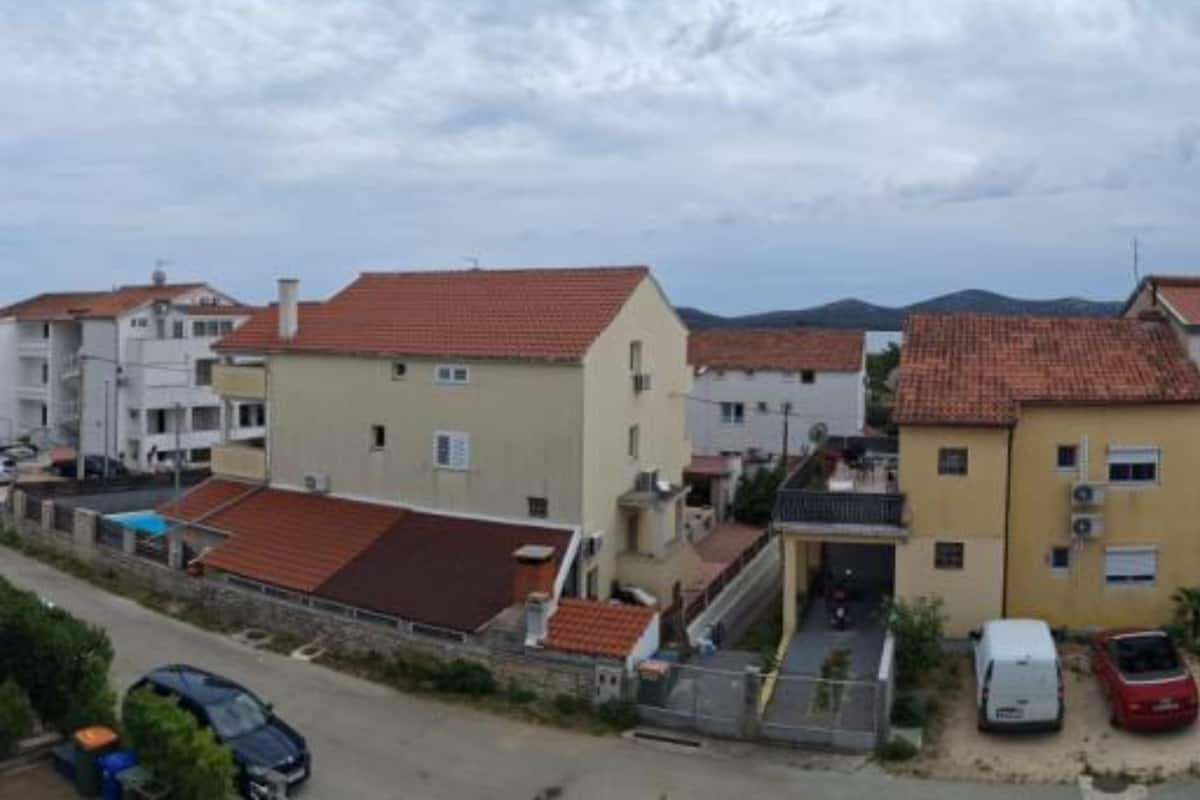 A residential area with houses featuring red-tiled roofs and a mix of architectural styles.